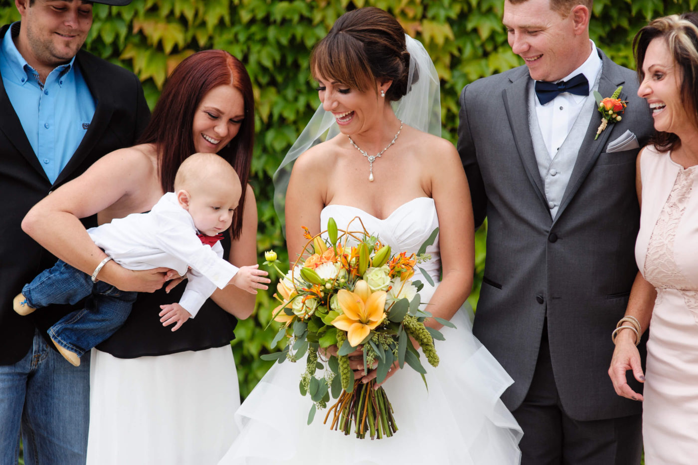 baby reaches bride bouquet wedding family portrait