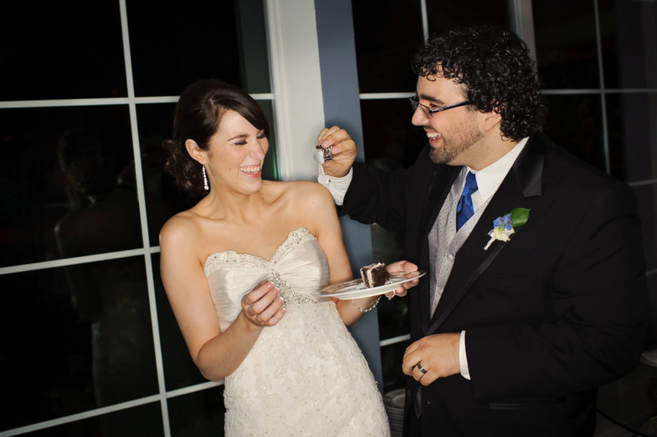 groom feeds bride cake wedding reception