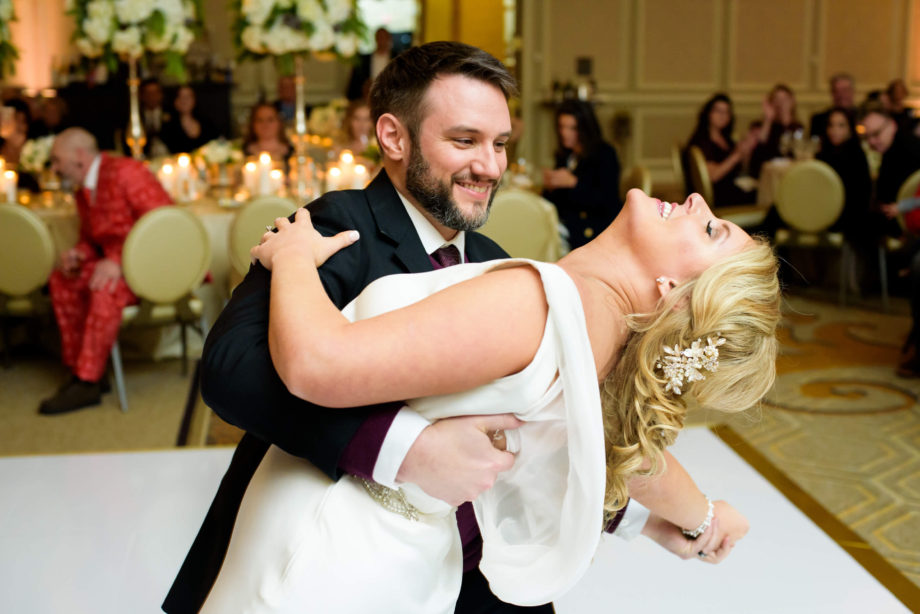 groom dips bride first dance wedding reception